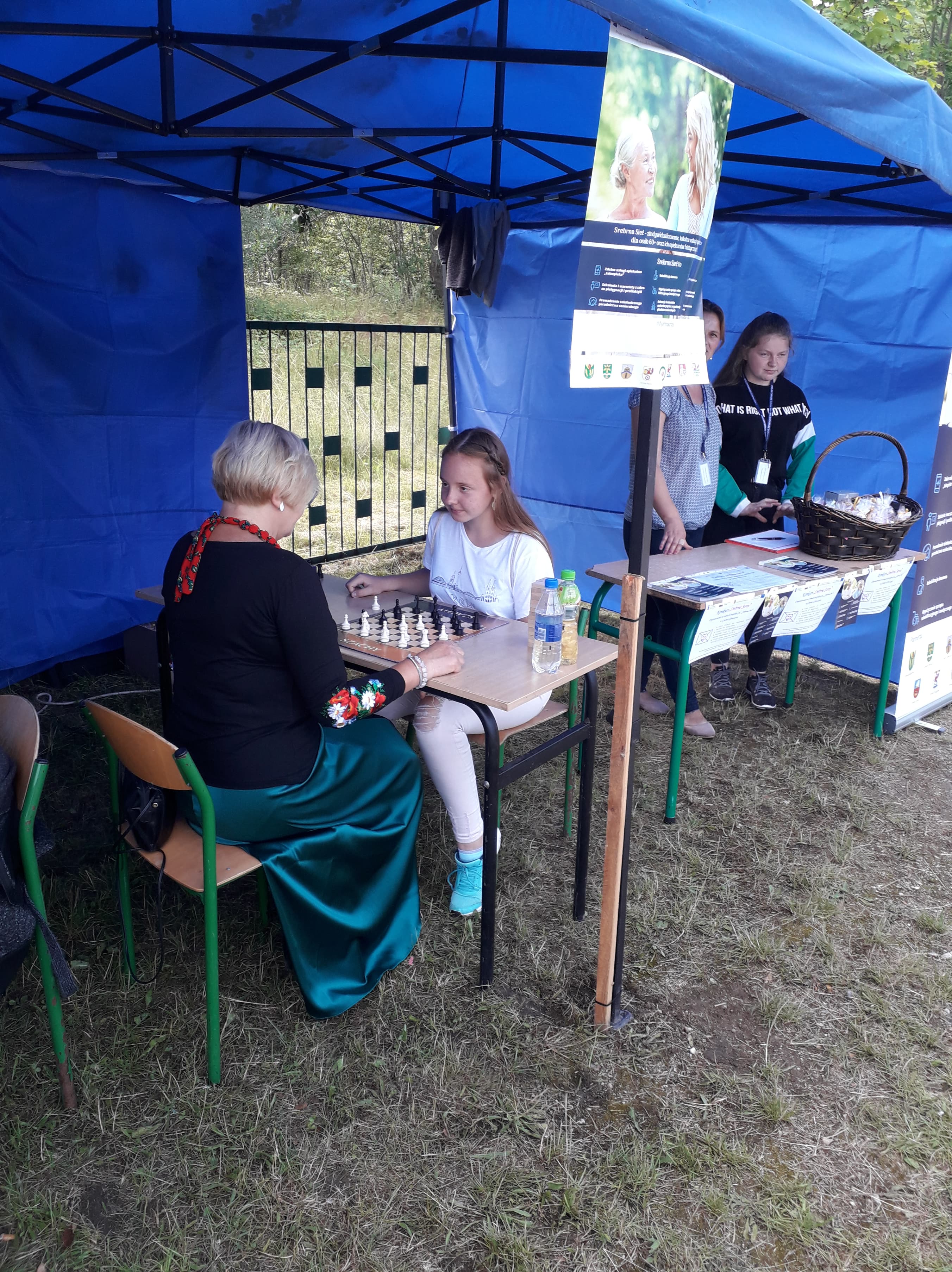 Uczestnicy Główczyckiego Festiwalu Lata grający w gry planszowe pod namiotem promującym projekt Srebrna Sieć.