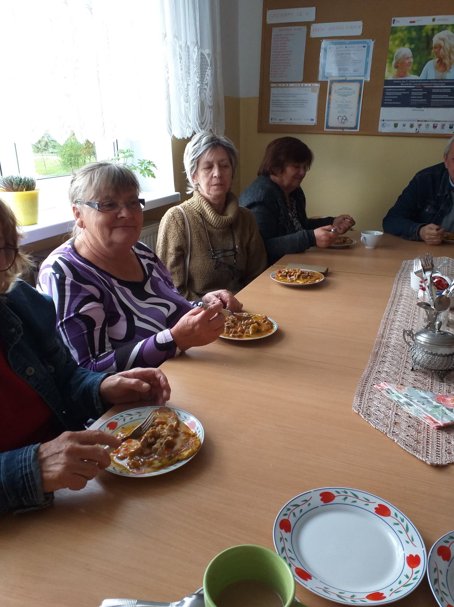 Uczestnicy Klubu Seniora spożywający przygotowane potrawy