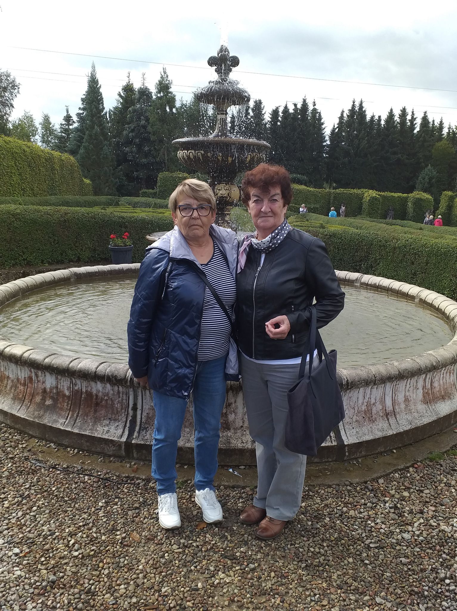 Dwie seniorki na tle fontanny w ogrodzie Hortulus