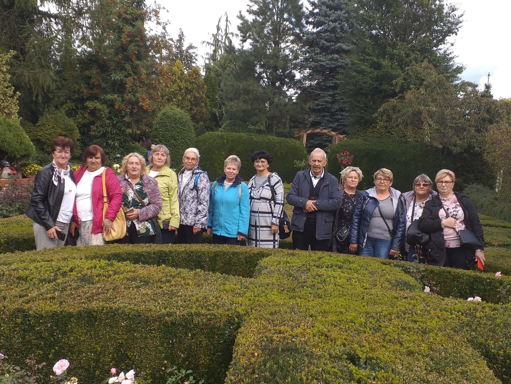 Grupa seniorów pozująca do zdjęcia w ogrodzie Hortulus